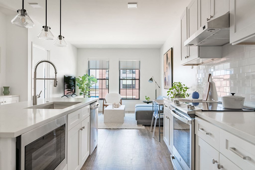 Open plan kitchen and living room with modern furniture, pendant lights and appliances