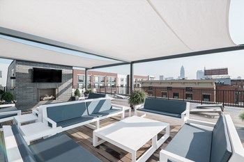 Rooftop lounge featuring couches, awning, television and fireplace. Downtown Cleveland can be seen in distance. - Photo Gallery 25