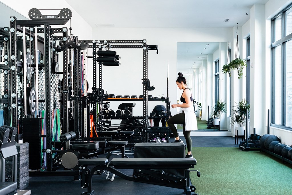 Woman exercising in The Mill gym, surrounded by equipment