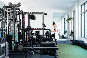 Woman exercising in The Mill gym, surrounded by equipment - Photo Gallery 24