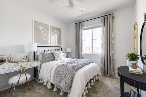 A bedroom with a large bed and a window with curtains.