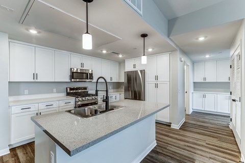 A modern kitchen with a large island and stainless steel appliances.