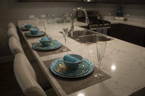 A kitchen counter with a plate and a glass on it.