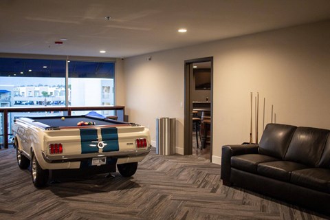 a pool table sits in the middle of a room with a couch and chair at The Crossings at Redlands, California, 92374