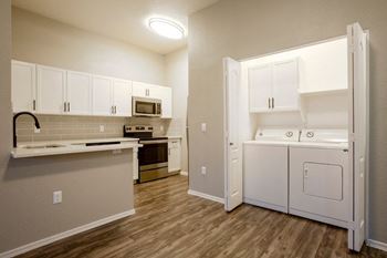 a kitchen with white appliances and a white washer and dryer at Ascent North Scottsdale Apartments, Phoenix