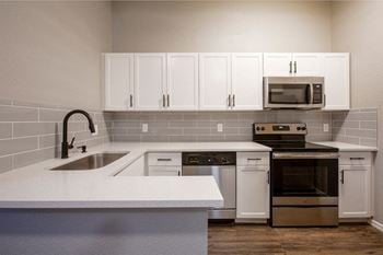 a kitchen with a sink stove and microwave