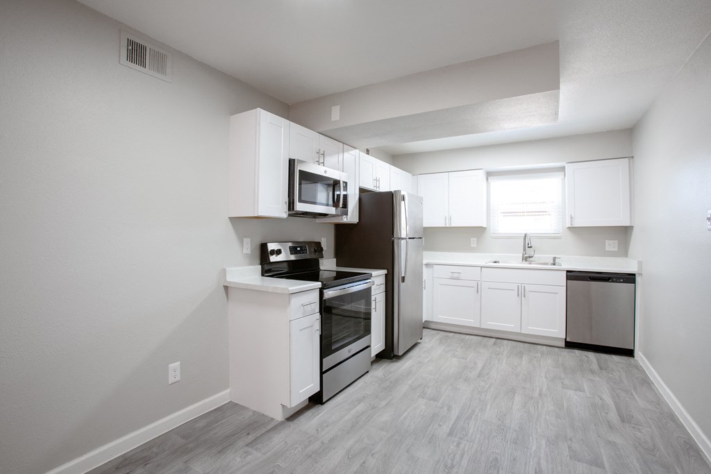 an empty kitchen with white cabinets and stainless steel appliances at Ascent on Peoria Apartments, Arizona, 85029