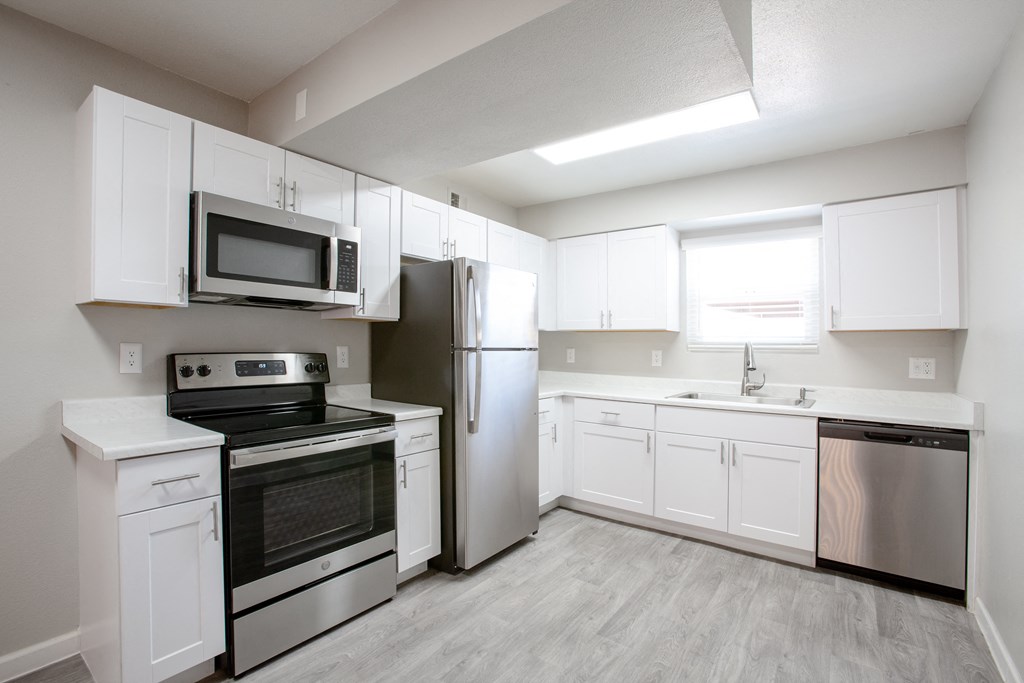 an empty kitchen with white cabinets and stainless steel appliances at Ascent on Peoria Apartments, Phoenix, AZ