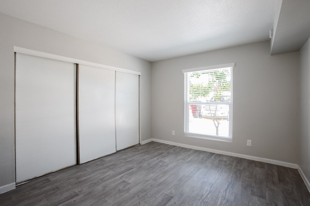 an empty room with white walls and wood flooring and a window at Ascent on Peoria Apartments, Phoenix, Arizona
