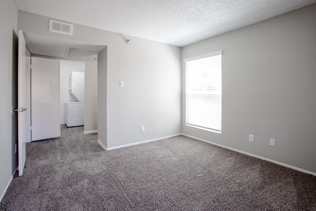 an empty living room with carpet and a large window at Ascent on Peoria Apartments, Arizona, 85029