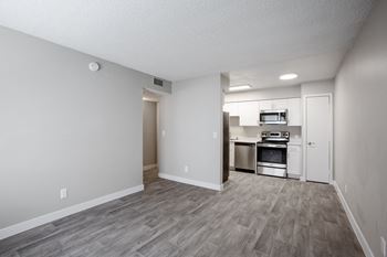an empty living room with a kitchen in the background at Ascent on Pantano Apartments, Arizona