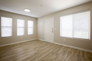 an empty bedroom with a door and three windows at 60 at Melrose Apartments, Phoenix, 85013