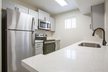 a kitchen with white cabinets and a white counter top at 60 at Melrose Apartments, Phoenix, AZ