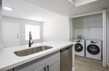a kitchen with a sink and a washer and dryer at 60 at Melrose Apartments, Phoenix