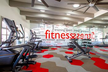 a fully equipped gym with cardio machines and weights at The Vintage Apartments, Tucson, South Carolina