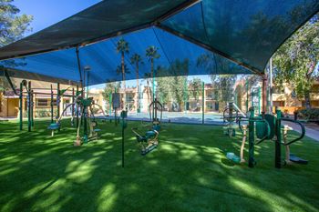 a playground with swings and other equipment on a sunny day at Ascent on Peoria Apartments, Phoenix, AZ 85029