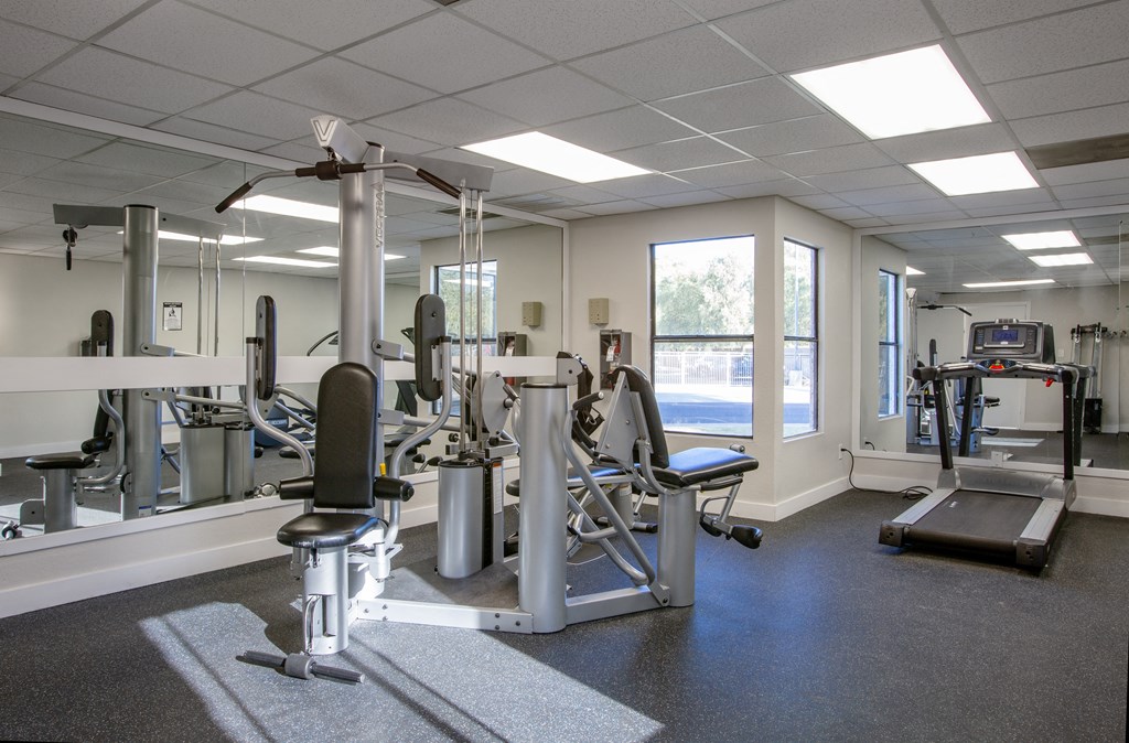 A gym with a variety of equipment including a treadmill, weights, and a bench press.at Ascent on Spence, Tempe, AZ 85281