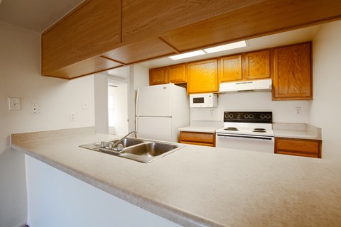A kitchen with wooden cabinets and white appliances.