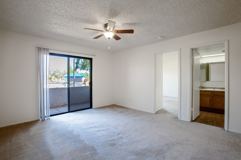 Empty room with a ceiling fan and sliding glass doors.at Ascent on Spence, Tempe, AZ 85281