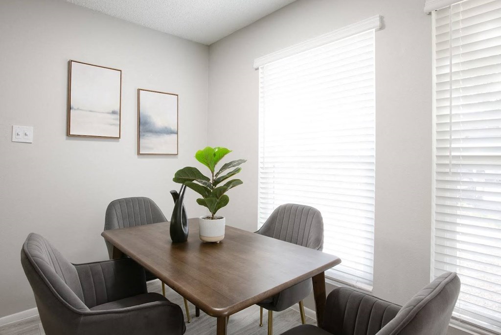 a dining room with two windows and a table with three chairs at Ascent on Peoria Apartments, Phoenix, Arizona