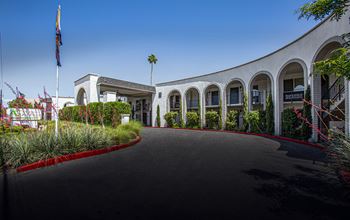 a large white building with a driveway in front of it
