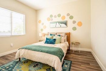 Model bedroom is furnished with a large bed and 2 nightstands at Village Greens of Queen Creek - Photo Gallery 4