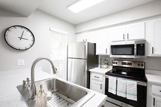 a kitchen with a sink stove refrigerator and microwave