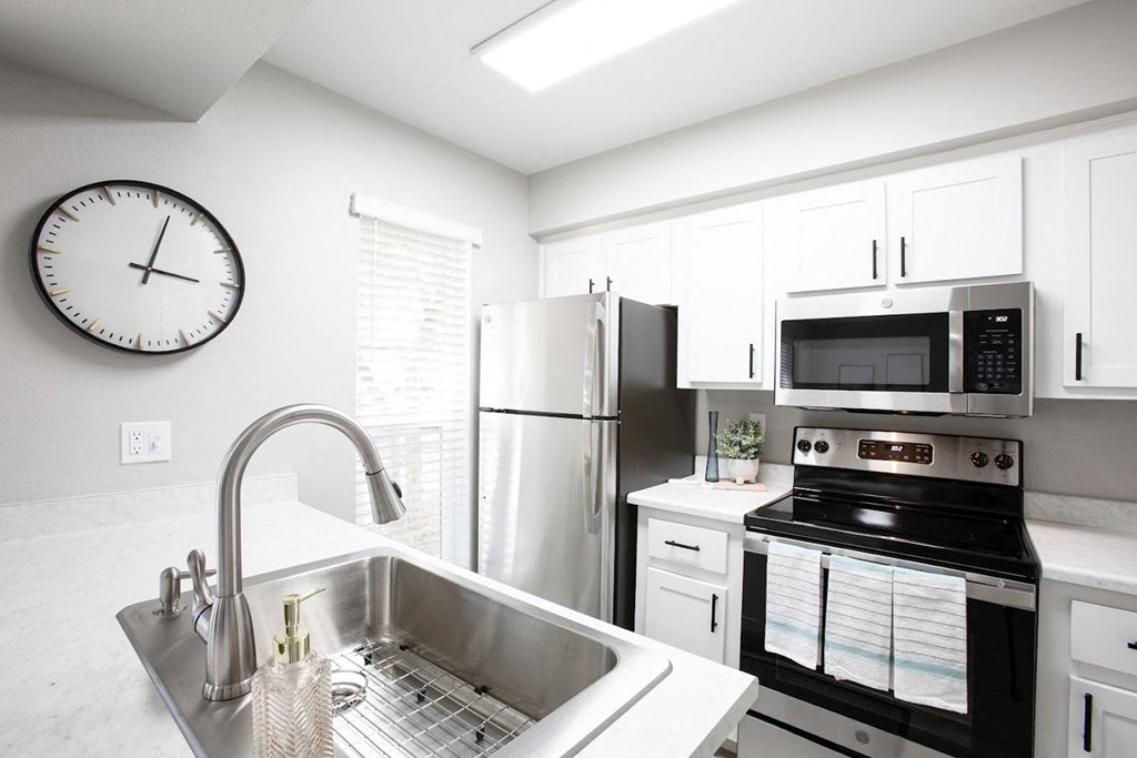 a kitchen with a sink stove refrigerator and microwave at Ascent on Peoria Apartments, Phoenix, AZ