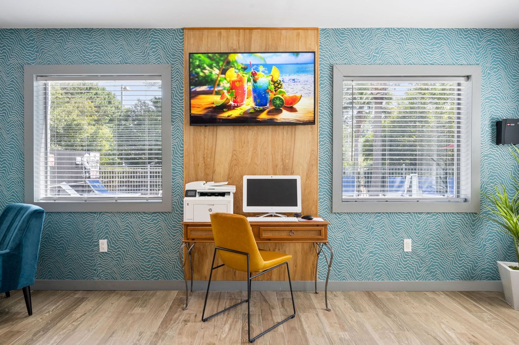 a computer desk with a yellow chair and a painting on the wall at Nextloft Apartments, Bluffton, SC