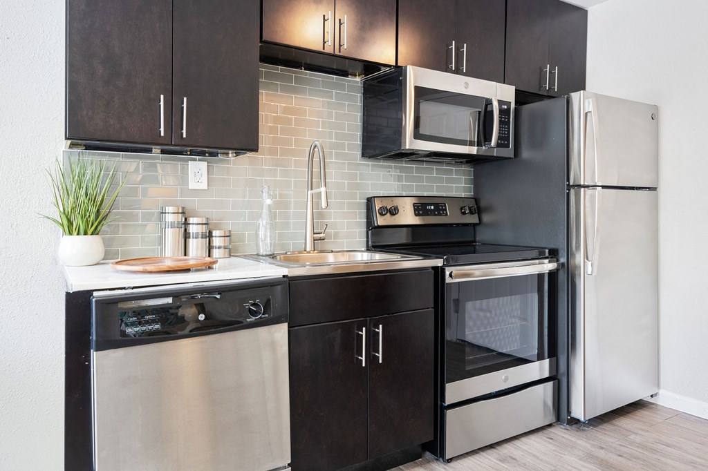 a kitchen with modern cabinets and stainless steel appliances at Nextloft Apartments, Bluffton, SC