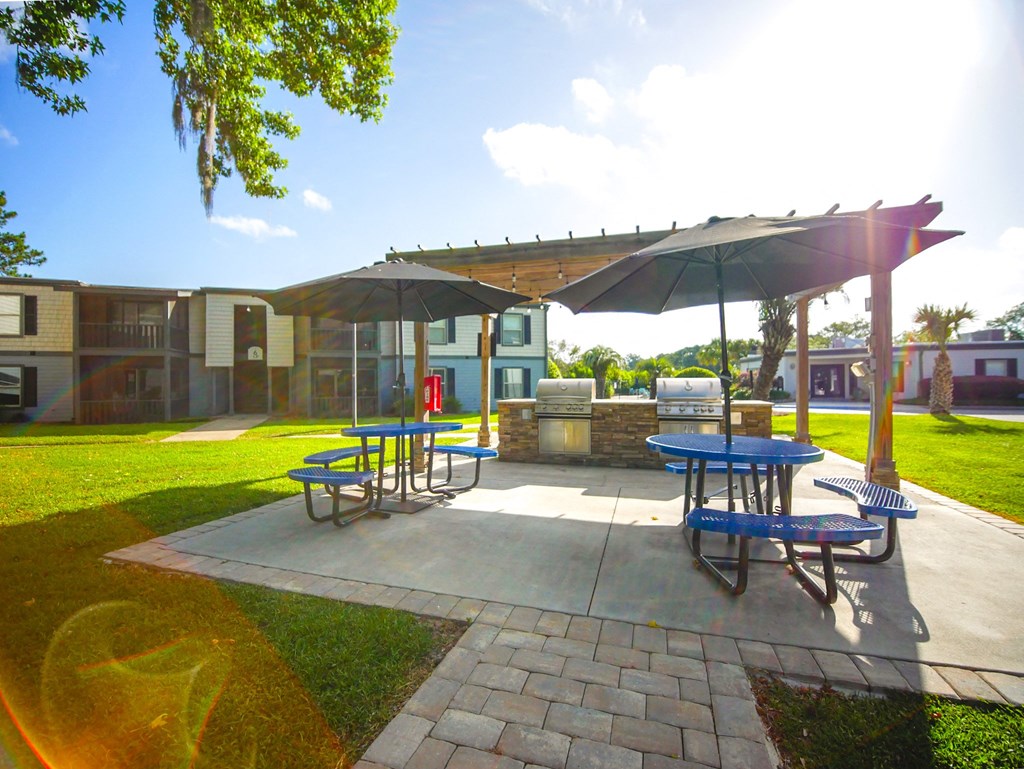 a patio with picnic tables and umbrellas