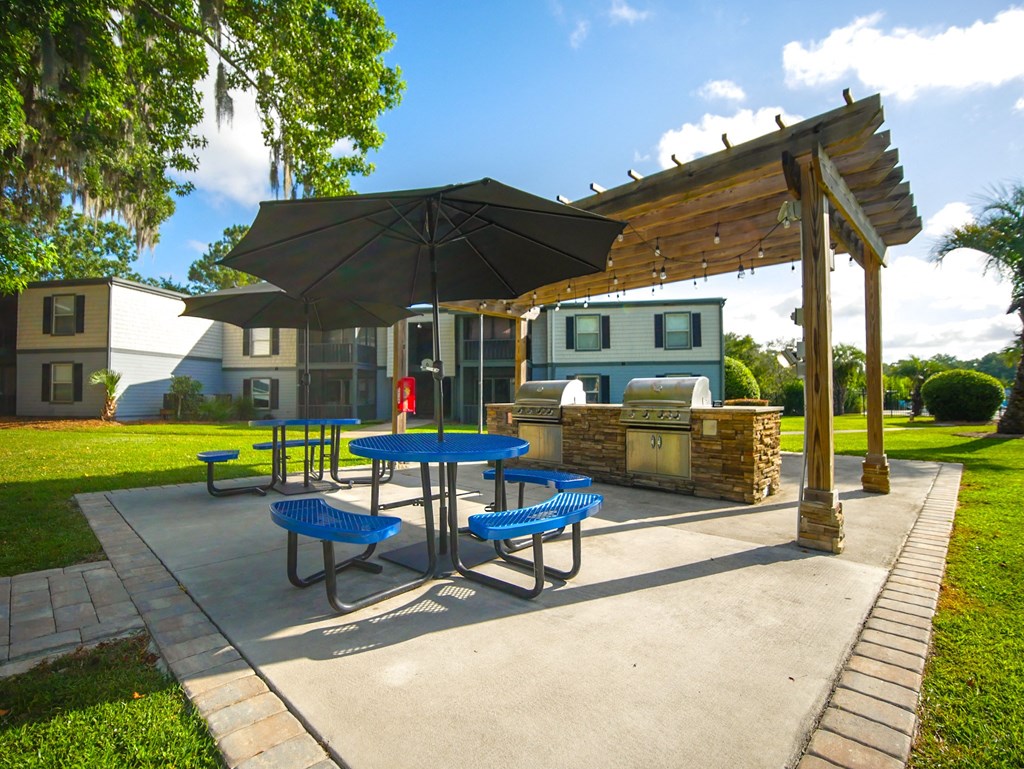 a patio with a picnic table and an umbrella