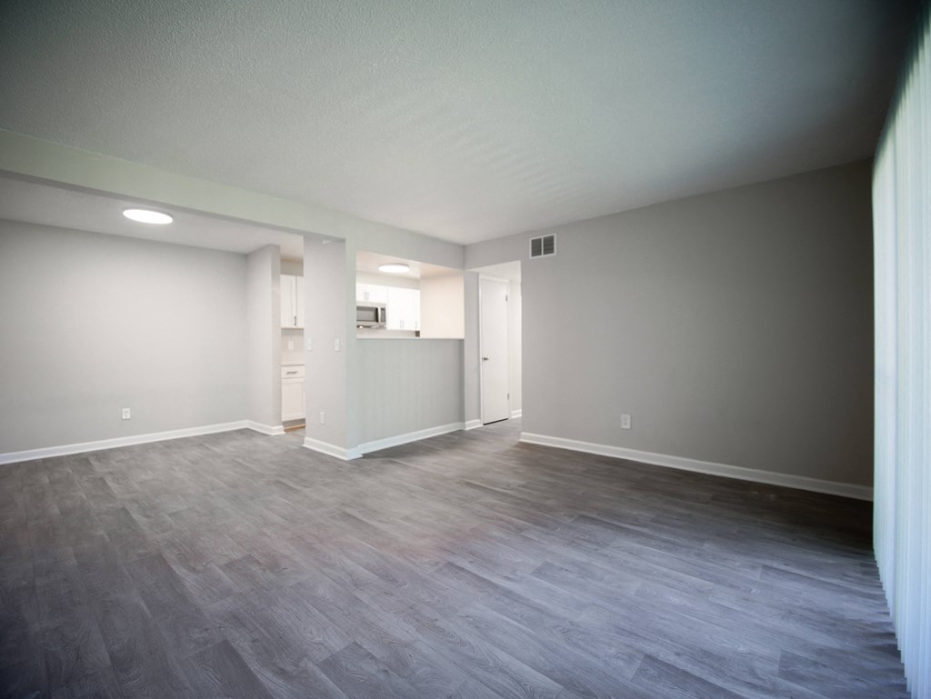 the living room and kitchen of an empty house