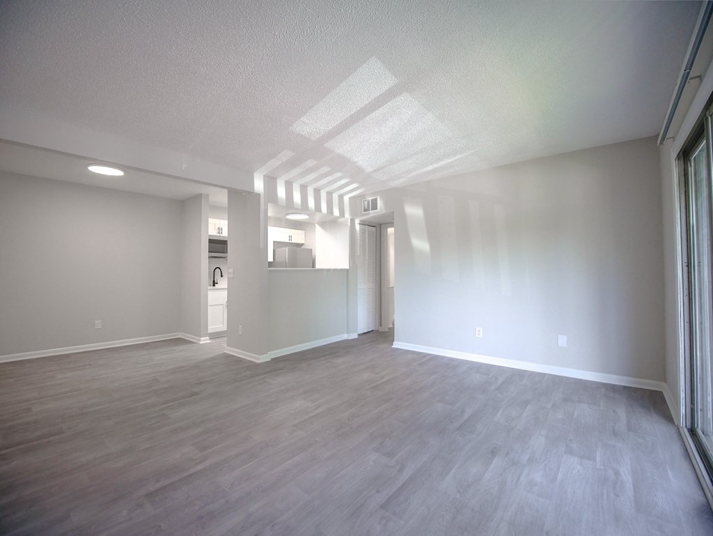 an empty living room with white walls and wood flooring