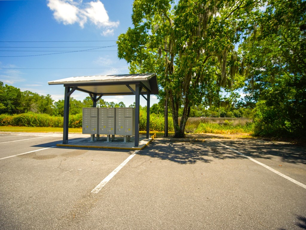a bus stop in a parking lot with trees