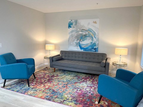 a living room with a couch and two blue chairs