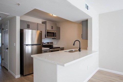 a kitchen with a counter top and a stainless steel refrigerator