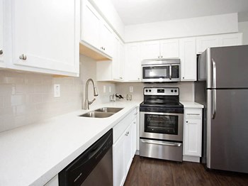 Phoenix apartment kitchen with quartz countertops, hardwood floors, and stainless steel appliances at Arcadia Gardens - Photo Gallery 3