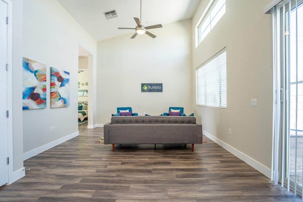 Wood-style flooring in a living room furnished with a couch at Village Greens of Queen Creek