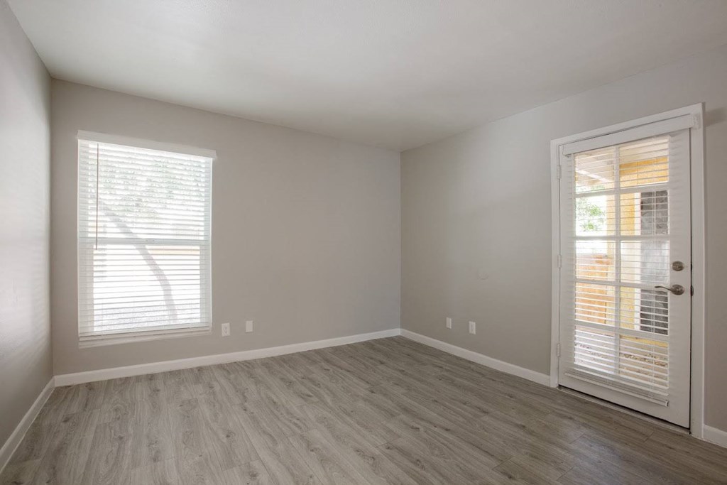 a bedroom with hardwood floors and a door leading to a balcony at Ascent on Peoria Apartments, Arizona