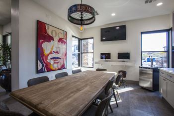 a long table with chairs and a painting on the wall