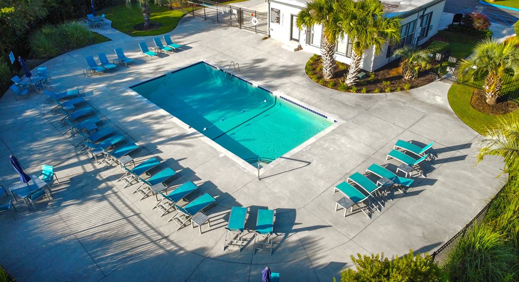 a swimming pool with chairs and chairs around it