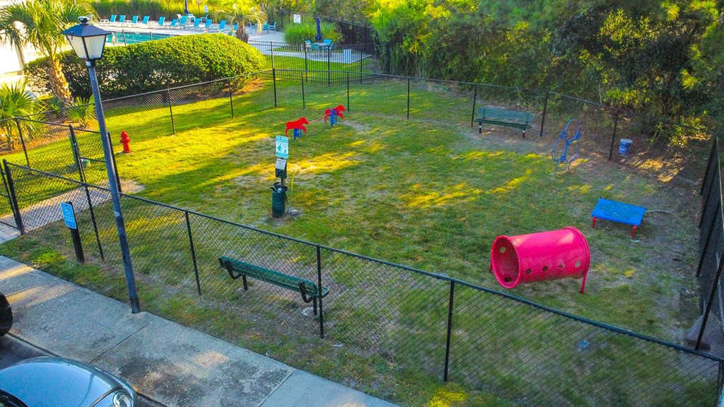 a playground in a park with benches and a fence