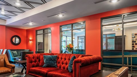 a living room with red furniture and large windows