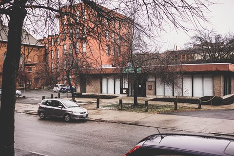 A car is parked on the side of a street in front of a building.