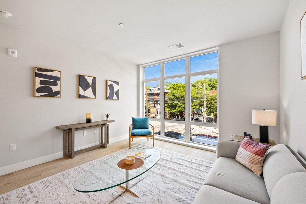 a living room with a couch and a chair and a large window