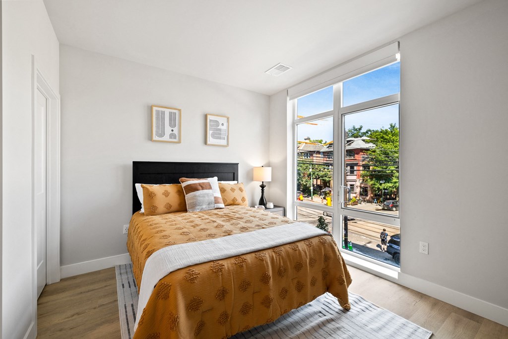 a bedroom with a bed and a large window