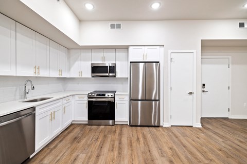 A kitchen with white cabinets and stainless steel appliances.