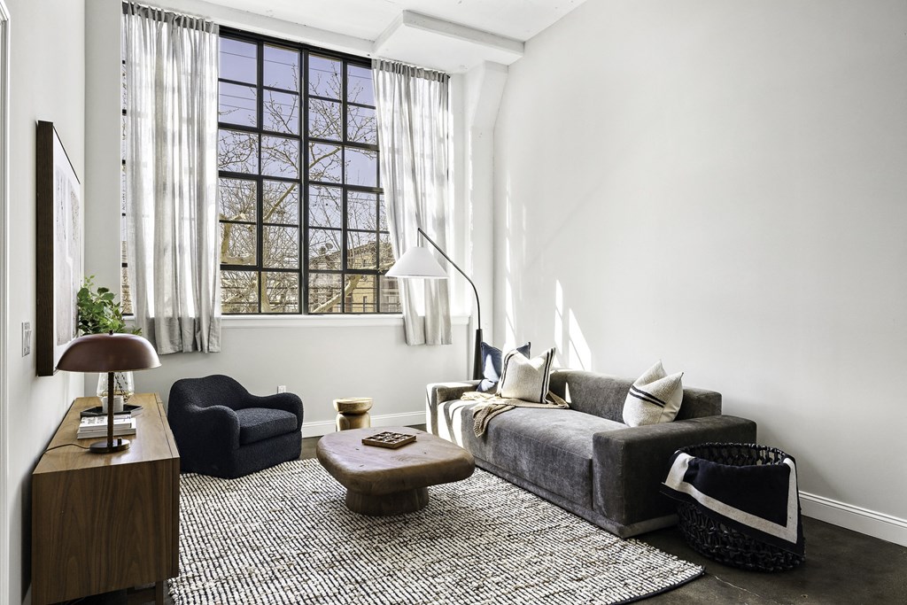 a living room with a couch and a chair and a window