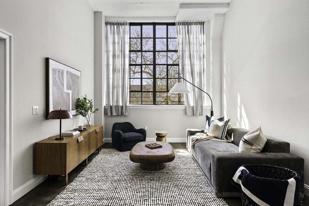 a living room with a gray couch and a window